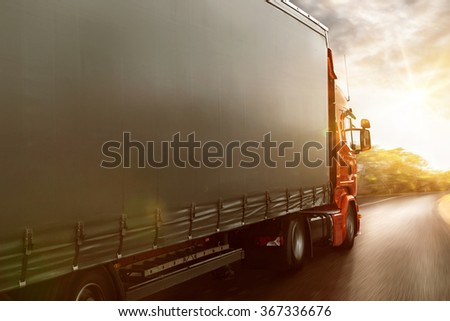 Truck drives on a country road at sunset