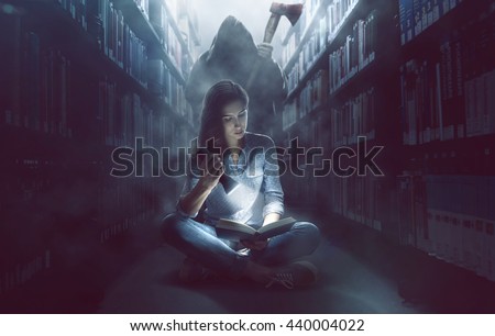 Woman reads a book in dark library