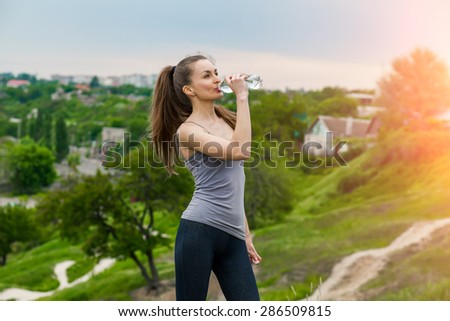 Athlete woman refreshing with Bottle of water after running workout outdoors. Woman drinking Water, Healthy active Lifestyle
