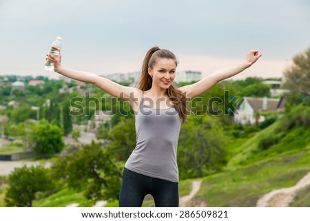 Athlete woman refreshing with Bottle of water after running workout outdoors. Woman Enjoying nature, Healthy active Lifestyle