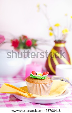 Fresh cake, White kettle, cup of tea, and yellow flowers on a checkered tablecloth