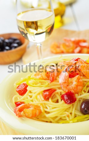 Seafood spaghetti pasta dish with shrimps and cherry tomatoes served with white wine