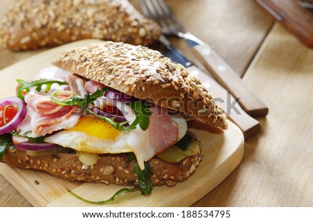 Bacon and fried eggs sandwich on the cut board
