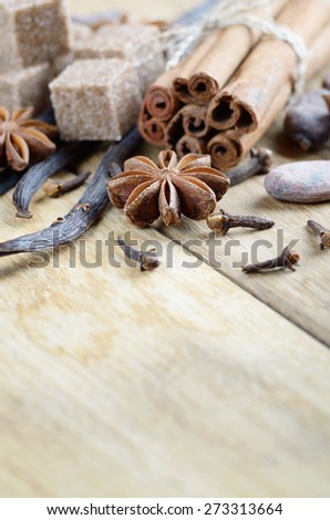 Vanilla, cinnamon, cocoa, anise and cloves on wooden table with copy-space