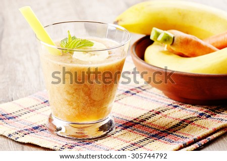 Carrot and banana shake on wooden table. Smoothie concept