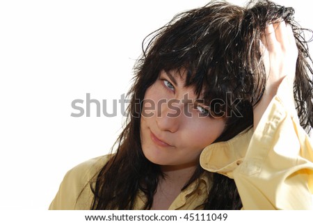 Young attractive girl in yellow shirt touching her brown wet hair.