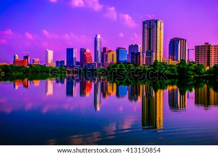 Mirror Reflection on Town Lake of Austin , Texas Skyline seen during early morning sunrise with pink clouds floating above a perfect mirror image of the cityscape from the riverside pedestrian bridge