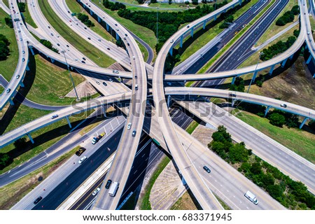 Hi above highways and interchanges the roads band and the interstate takes you on a fast transportation highway in Austin Texas drone view looking down from above