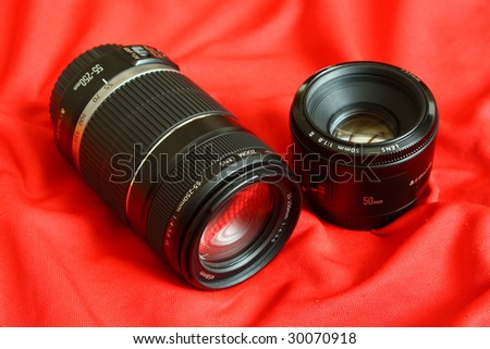 Camera lenses on red canvas