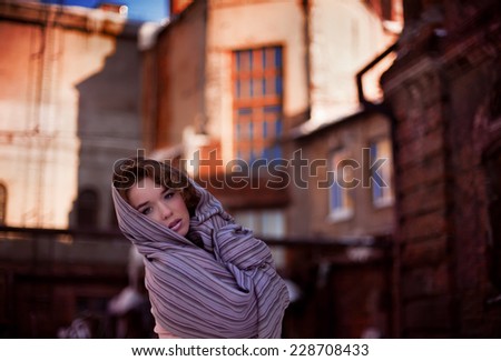 woman in a scarf on the background of an old building