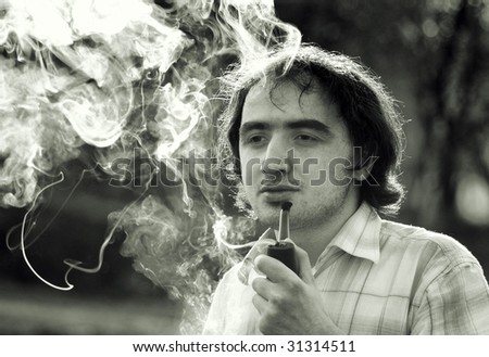 handsome young man with a happy pipe smoking