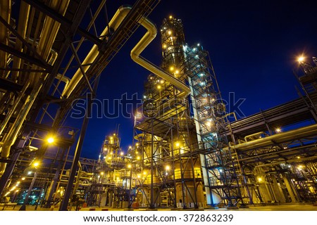 Pipes and buildings of big factory in darkness