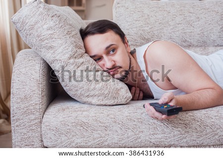 guy lies on his belly and watches TV