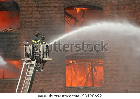Firemen on a lift up extinguishing fire