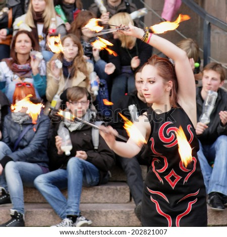 KAUNAS, LITHUANIA - MAY 7: Girl dancing with torches in pedestrian street during Street Music Day on May 7, 2011 in Kaunas, Lithuania
