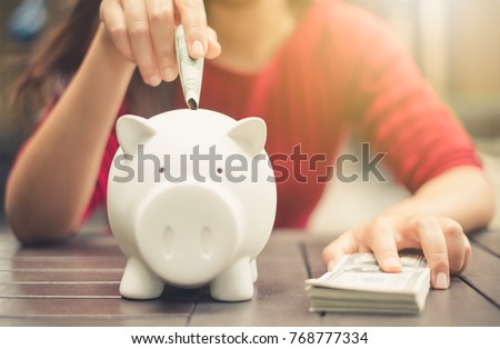 woman hand putting money bank note dollar into piggy for saving money wealth and financial concept.