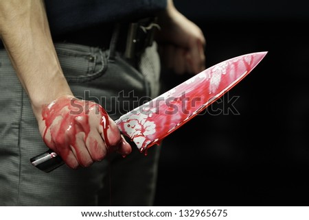 Man holding knife with blood dripping