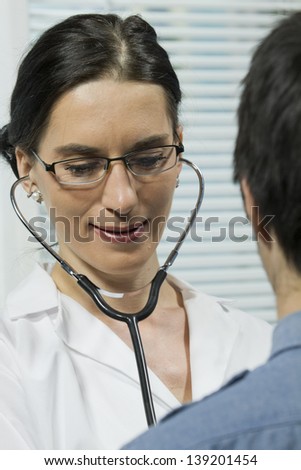Female doctor listening to patient\'s heart