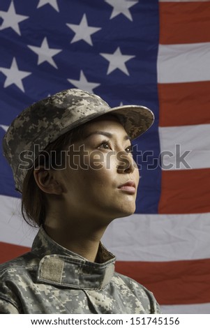 Military woman in front of US flag, vertical
