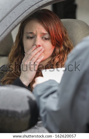 Young woman panics as she is pulled over by police, vertical