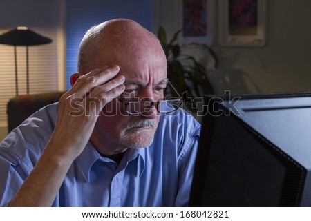 Stressed older man looking at computer, horizontal