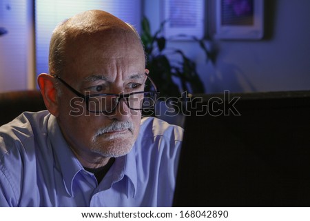 Older man studying computer, horizontal