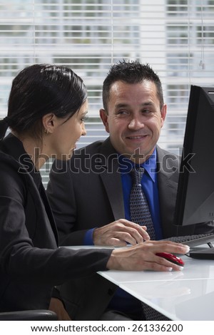 Hispanic man and Hispanic woman discussing business