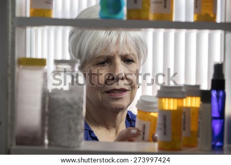 Senior woman looks at prescription bottles