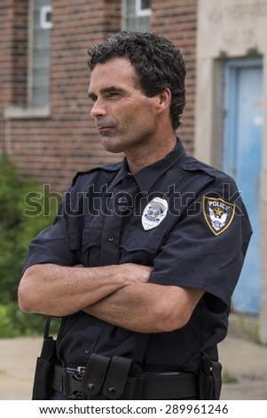 Portrait of a police officer, arms crossed, sideways shot