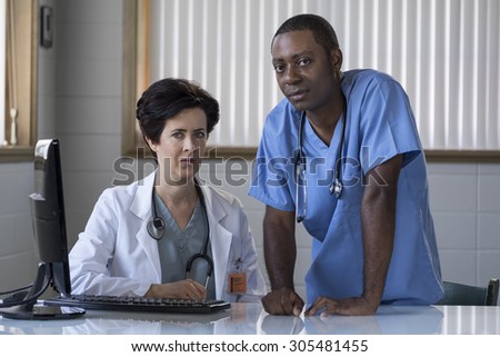 Proud Caucasian female doctor and African American male nurse