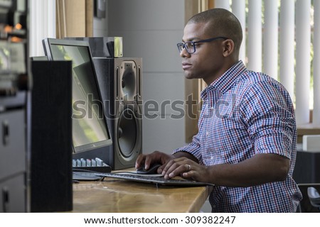Young professional man standing at his computer desk in the office