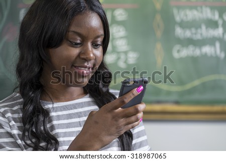 Young african american woman using a cell phone in a cafe