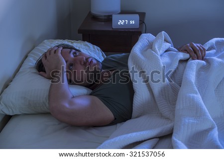 A man unable to fall asleep in bed