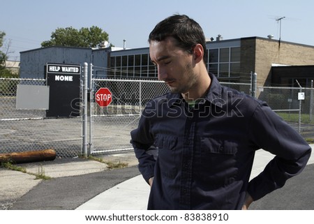 Out of work employee standing outside of factory