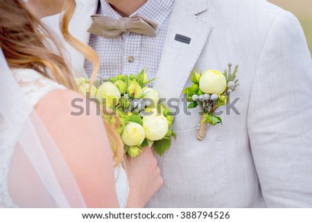 Beautiful wedding bouquet in rustic style with yellow peonies. bride with bouquet. the groom\'s beautiful boutonniere.