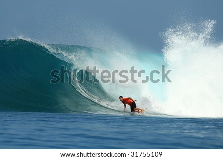 Surfer in red t-shirt on big wave, Mentawai Islands, Indonesia