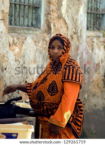 STONE TOWN - JANUARY 21 : Swahili woman prepares food 21 January, 2011. Stone Town, Zanzibar. Local people dines usually outside in Zanzibar, as part of their Swahili custom.