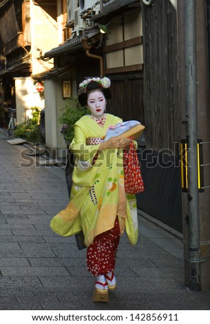 KYOTO, JAPAN - JUNE 14: Maiko in kimono in Gion historical district June 14, 2013, Kyoto, Japan. Maiko is a geisha apprentice, a popular form of Japanese entertainment, left from the medieval times.