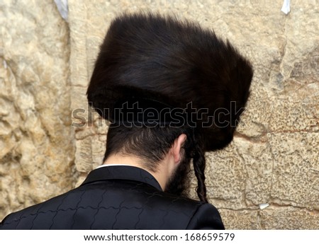 JERUSALEM, ISRAEL - DECEMBER 6: Orthodox Jewish man prays at the Western Wall on December 6, 2013, Jerusalem, Israel. The Wall is the holiest place for Jewish people. All of them go there to pray.