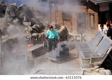 OWAKUDANI, JAPAN - MARCH 28 : Local man boils eggs in the  steam of Mt. Fuji on March 28, 2008 in Owakudani, Japan. This steamed egg is famous among the Japanese tourists.
