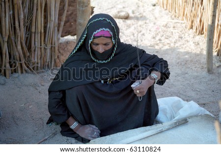 EASTERN DESERT, EGYPT - NOVEMBER 22 : Bedouin woman prepares food in the village on November 22, 1998 in Eastern Desert, Egypt. Bedouins live in harsh conditions in the desert.
