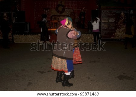 BUDAPEST, HUNGARY - NOVEMBER 24: Old ladies dance in national costume in the Christmas Market at November 24, 2010, Budapest, Hungary. The Budapest Christmas Market is the biggest in Eastern Europe.
