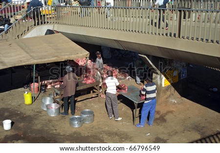 SOWETO, SOUTH AFRICA - JULY 18: Butcher in the market, July 18, 2005 at Soweto, South Africa. Local markets in Africa are close to stations, so passengers can make their shopping on the spot.