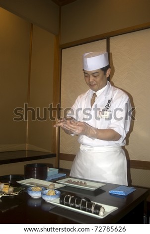 TOKYO - FEBRUARY 24: Japanese cook prepares sushi on a food fair on February 24, 2011 in Tokyo. Sushi is the world famous gem of Japanese cooking.