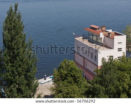 The house near the river with trees.