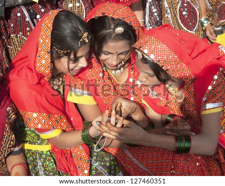 PUSHKAR, INDIA - NOVEMBER 21:  A trio of  unidentified girls in colorful ethnic attire attends at the Pushkar fair on November 21, 2012 in Pushkar, Rajasthan, India.