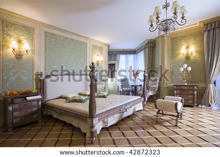 Master bedroom with beautiful bed and linens and sitting area by the 