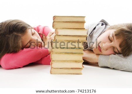 Two young teenage girls with pile colored book fell asleep after hard learning.
