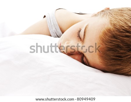 Nine year old boy sleeping and dreaming, isolated on white.