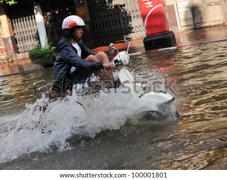 BANGKOK - NOVEMBER 1: An unidentified motorbike rider navigates a flooded street in Chinatown after the heaviest monsoon rains in over 50 years on November 1, 2011 Bangkok, Thailand.